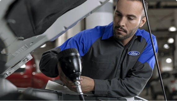 Ford Service Technician performing radiator repair on vehicle
