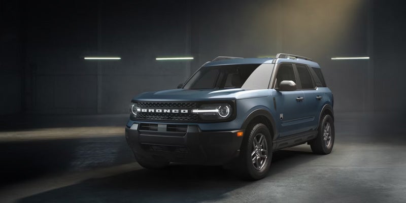 Three-quarter shot of a blue 2022 Ford Bronco Sport Badlands model in a dark studio.