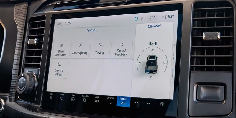 A car's dashboard screen displaying "Features," with options like Driver Assistance, Towing, and Off-Road settings.