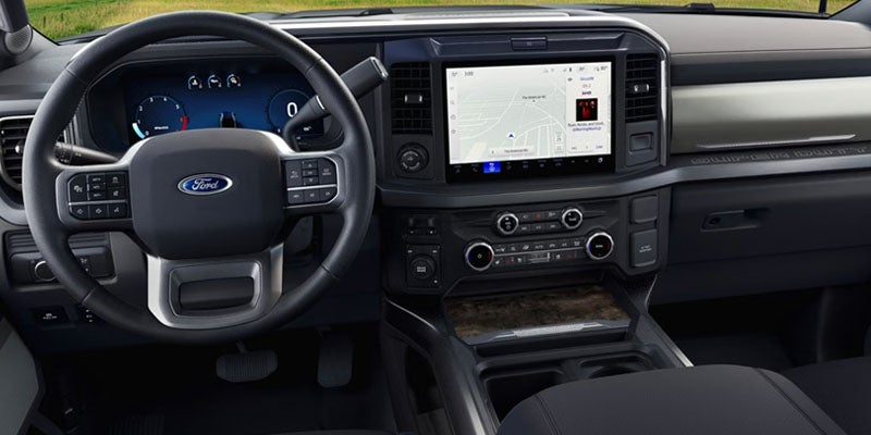 Interior shot of a car, showing the steering wheel with Ford logo, digital dashboard, and touchscreen navigation.
