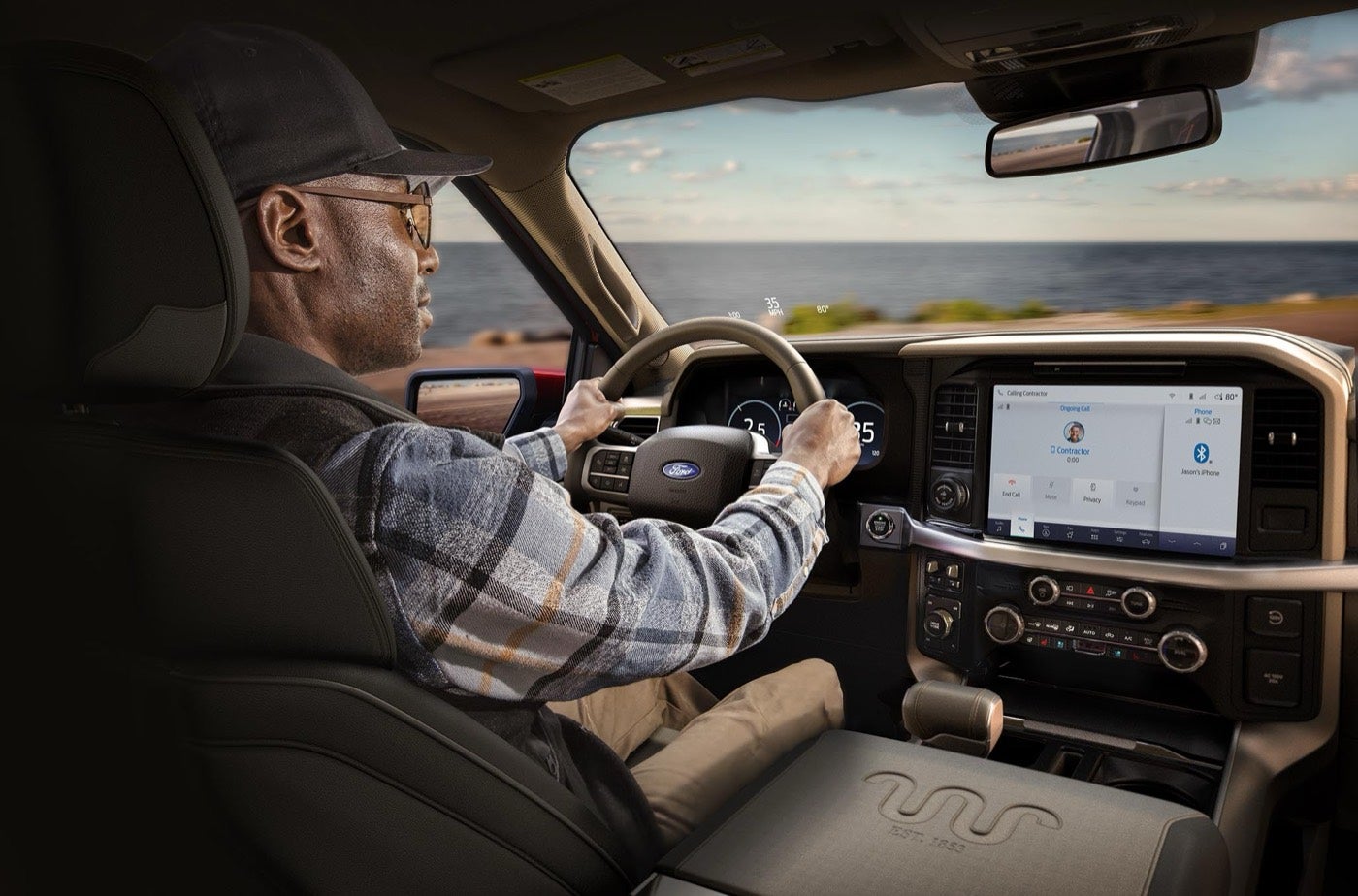 Driver in a Ford F-150 cabin with the center display on a hot day, AC service in Bowie, TX